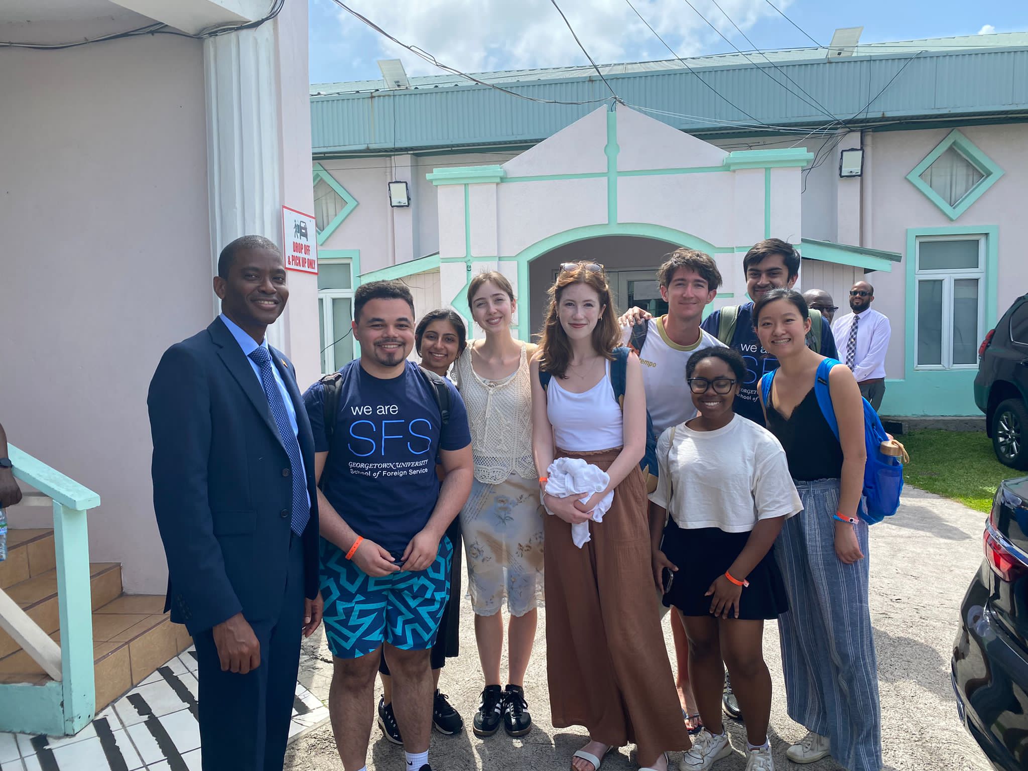 A group of people stand in front of a building and pose for a photo.