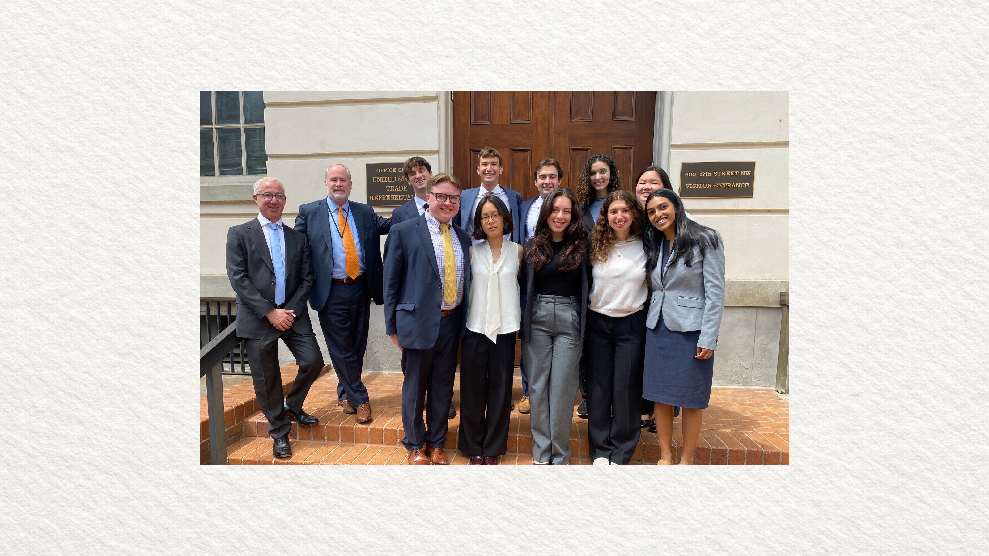 A group of people in professional attire stands together on brick steps in front of the U.S. Court of Appeals in Richmond.