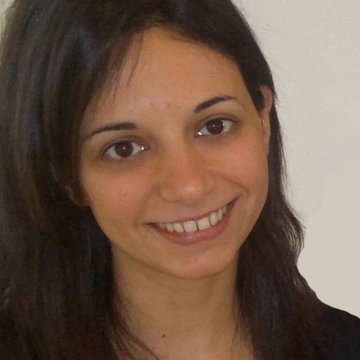 A woman with long brown hair, smiling.