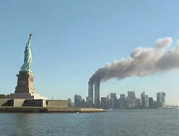 Smoke pours off of the Twin Towers in a picture of the New York City skyline and the Statue of Liberty on September 11, 2001.