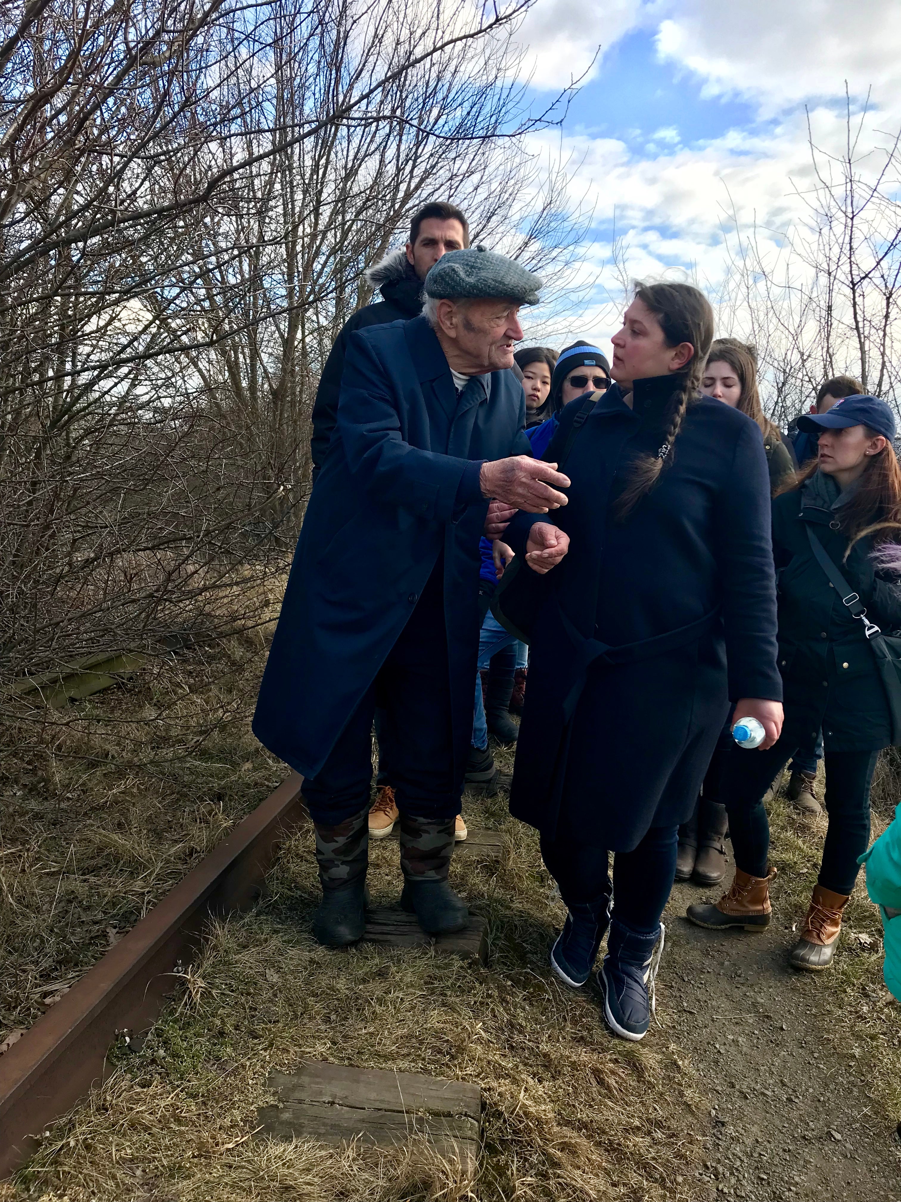 Group of people walk on former train tracks.